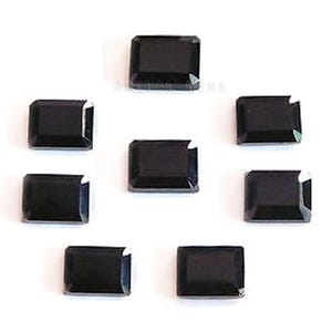 Puede incluir: Siete piedras preciosas negras rectangulares dispuestas en un patrón circular. Cada piedra presenta una superficie facetada con bordes afilados y un acabado pulido. El texto ARCHAI GEMS es ligeramente visible en el centro del conjunto.