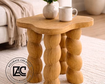 Mesa auxiliar escultural de madera con forma orgánica y detalles decorativos en madera maciza.