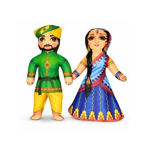 May include: Two fabric dolls depicting a couple in traditional Indian attire. The male doll wears a green tunic, yellow pants, and a yellow turban. The female doll wears a blue and red sari with a long black braid. They are holding hands.