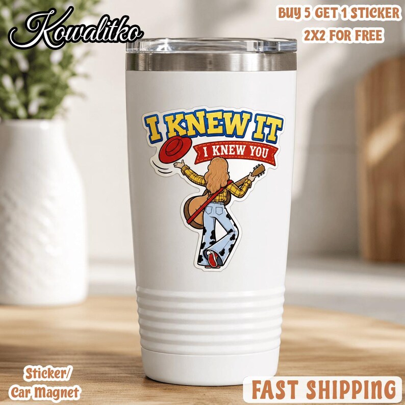 May include: A white stainless steel tumbler featuring a graphic of a person with long hair wearing a yellow plaid shirt and cow-print bell-bottom pants, holding a guitar and a red hat, with the text I KNEW IT I KNEW YOU printed above.