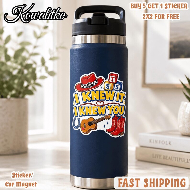 May include: A dark blue stainless steel water bottle with a black lid. The bottle features a sticker with a red cowboy hat, a guitar, red boots, and blocks with the letters T, S, and 5. The text reads I KNEW IT I KNEW YOU.