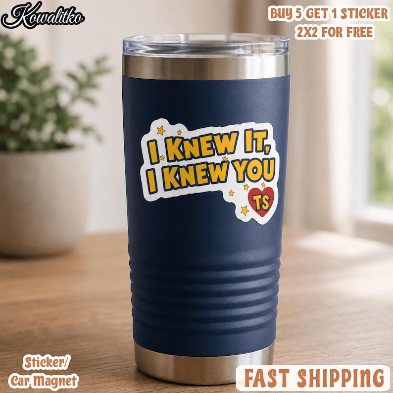May include: A dark blue stainless steel tumbler with a silver rim and base. The center features a white sticker with yellow text that reads I KNEW IT, I KNEW YOU, accompanied by small yellow stars and a red heart containing the letters TS.