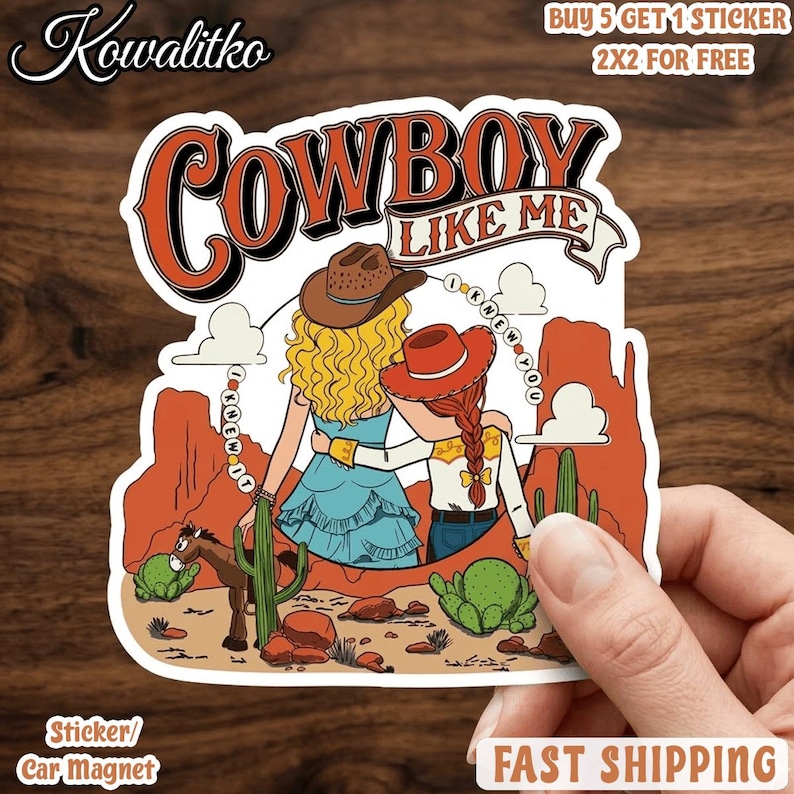 Op de afbeelding: Een gestanste sticker met twee figuren in cowboyhoeden in een woestijnlandschap met cactussen en rode rotsformaties. De tekst luidt COWBOY LIKE ME en I KNEW IT I KNEW YOU. De figuren hebben blond en rood haar en dragen westerse kleding.