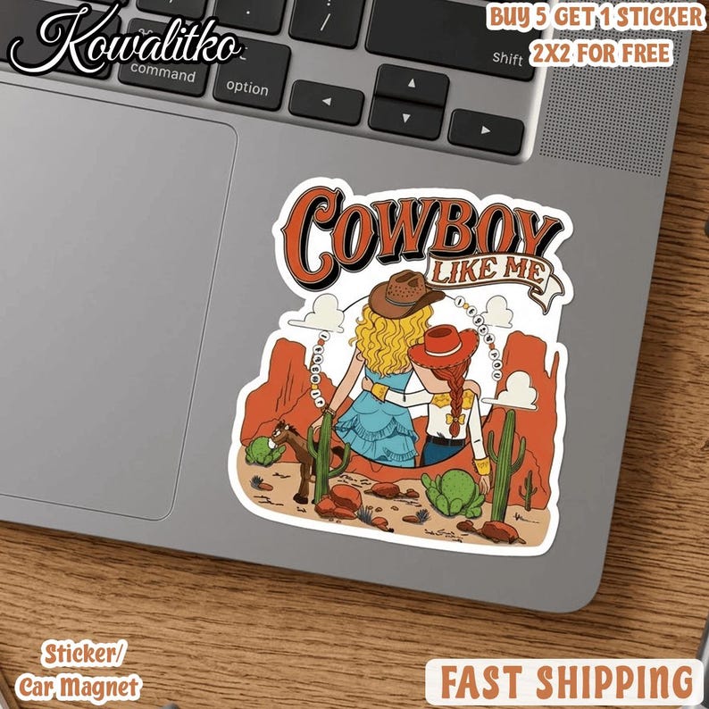 Op de afbeelding: Een gestanste sticker met de tekst COWBOY LIKE ME boven een illustratie van twee figuren met blond en rood haar die cowboyhoeden dragen, staand in een woestijnlandschap met rode rotsformaties, groene cactussen en een klein bruin paard.