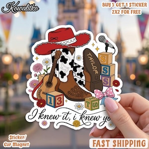 May include: A sticker featuring a red cowboy hat, brown and white cow-print boots, an acoustic guitar, a microphone, and alphabet blocks labelled with letters and numbers. The text reads 'TAYLOR', '13', 'TS', and 'I knew it, i knew you'.
