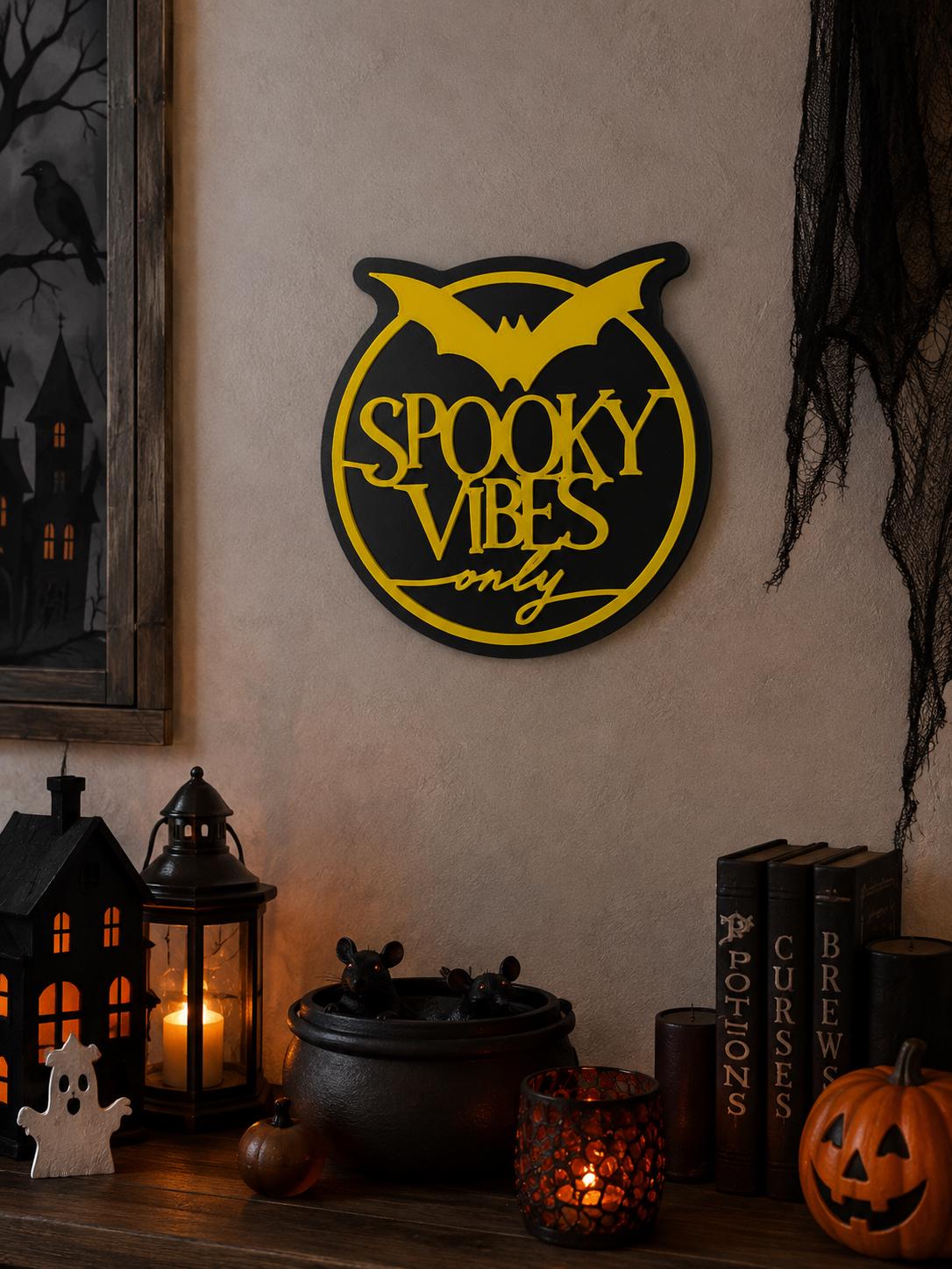 A yellow and black Spooky Vibes Only sign mounted on a wall above a Halloween themed mantle display.