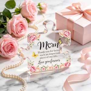 May include: A clear acrylic puzzle piece plaque featuring floral illustrations of pink and peach roses, two yellow butterflies, and black text that reads: Mom, Thank you for being such an important piece of my life. Love you forever.