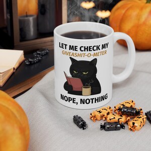 May include: A set of three ceramic mugs with a speckled, matte finish. The mugs are in shades of cream, light brown, and dark brown. Each mug has a simple, minimalist design and a rounded handle. The mugs are likely for coffee or tea.