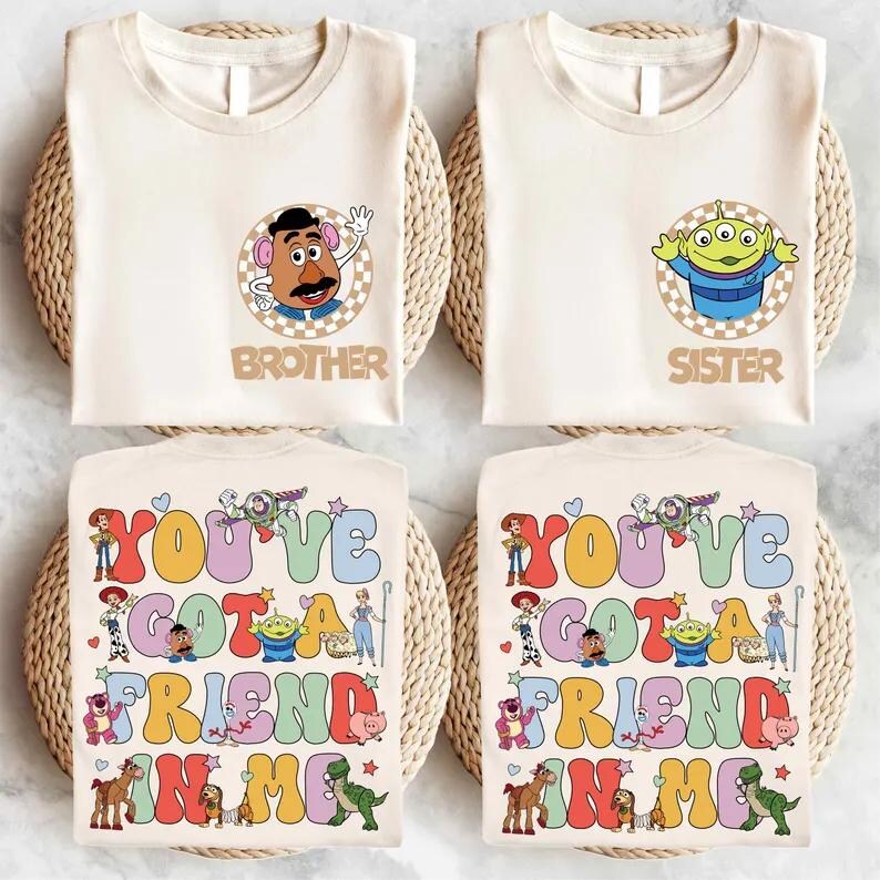 May include: Four cream-coloured t-shirts with Toy Story graphics. Two shirts feature Mr. Potato Head and an alien, with the words "Brother" and "Sister." The other two shirts display the phrase "You've Got a Friend in Me" with character illustrations.