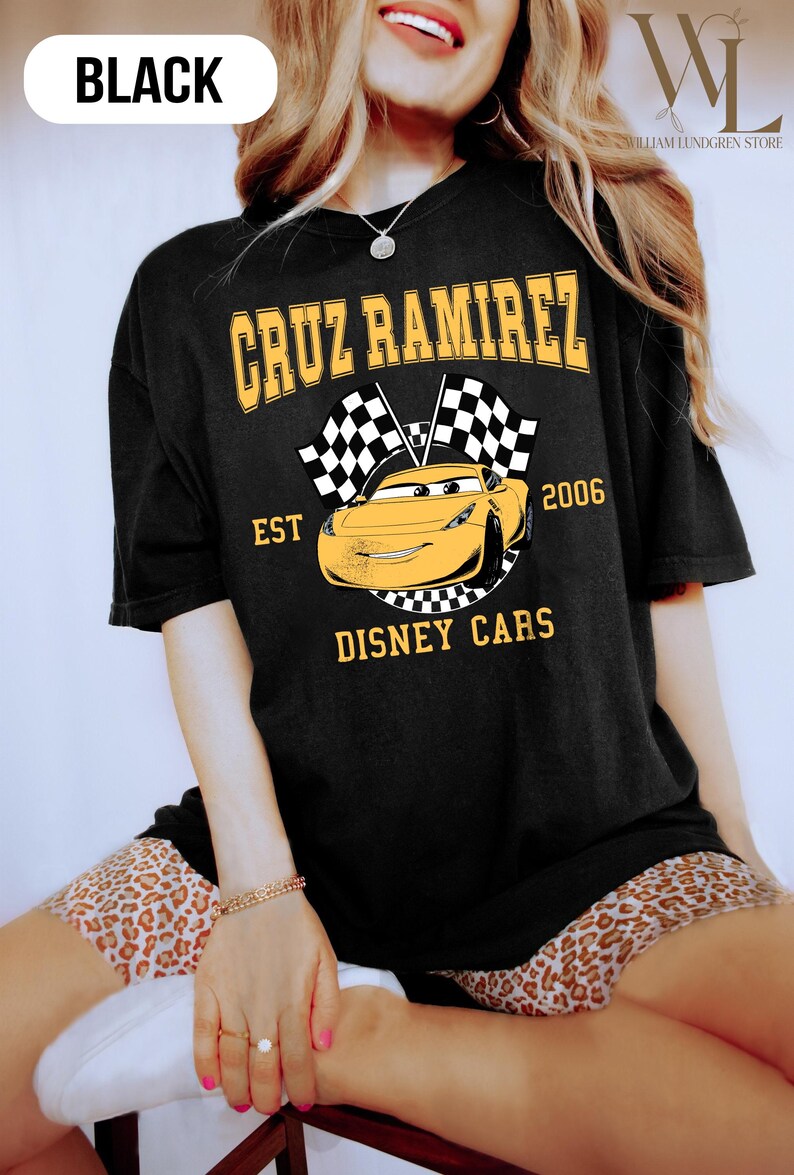 May include: A white ceramic mug with a black handle and the text "But First, Coffee" in a bold, black font. The mug is filled with a dark liquid, likely coffee, and sits on a light-colored surface.