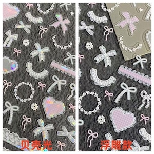 May include: A sheet of adhesive stickers featuring various designs including white lace collars, small pink and white bows, floral wreaths, and heart shapes. Some stickers have a holographic finish while others have a textured, raised appearance.