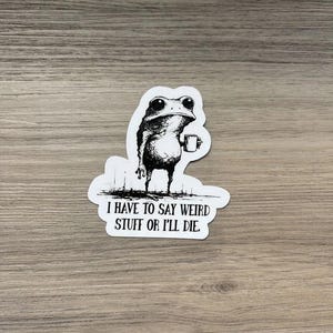 Peut inclure: Un autocollant découpé présentant une illustration à l'encre noire et blanche d'une grenouille tenant une petite tasse. Sous la grenouille, le texte indique : I HAVE TO SAY WEIRD STUFF OR I'LL DIE. L'autocollant a une bordure blanche.