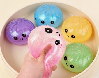 Kawaii Steamed Bun Squishy Toy in Glittery Pink, Green, Blue, or Gold – Served in Mini Steamer Basket for Calm & Joy