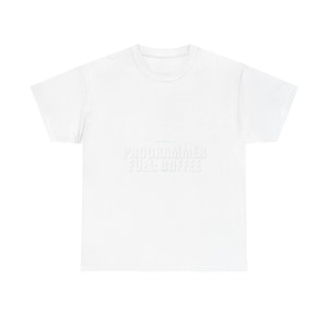 Peut inclure: Un t-shirt blanc avec le texte "PROGRAMMER FUEL: COFFEE" en blanc, dans une police légèrement vieillie. Le t-shirt a un col rond et des manches courtes. Le texte est centré sur le devant du t-shirt.