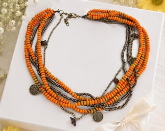 Collana a strati con perline arancioni e monete tribali, gioiello etnico boho fatto a mano.