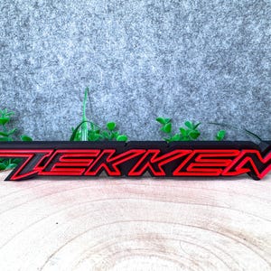 Può includere: Una tazza di ceramica bianca con manico nero e la scritta "But First, Coffee" in grassetto nero. La tazza è posta su uno sfondo sfocato, che suggerisce un'atmosfera accogliente.