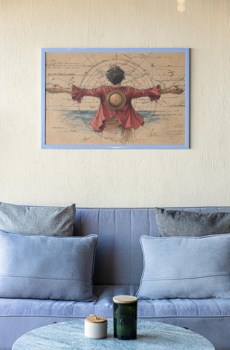 Puede incluir: Obra de arte enmarcada que representa a un personaje de la serie de anime One Piece, con los brazos extendidos, vistiendo una chaqueta roja y un sombrero de paja. El fondo incluye un dise&ntilde;o de mapa y un marco azul. La obra est&aacute; sobre un sof&aacute; azul con cojines grises.