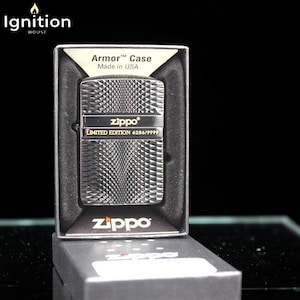 May include: A silver Zippo lighter with a diamond pattern, presented in a black box. The lighter is a limited edition, marked 6286/9999, and is an Armor Case, made in the USA. The Zippo logo is visible on the lighter and the box.