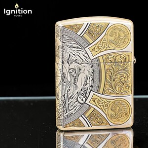 May include: A silver and gold metal lighter with a detailed engraving of a Grim Reaper figure holding a scythe. The lighter has ornate Celtic knot and floral designs. The text "Ignition House" is in the upper left corner.