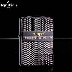 May include: Black Zippo lighter with a geometric pattern. The lighter has a black band with the Zippo logo in gold and the text "LIMITED EDITION 0299/9999". The lighter is a collectible item.