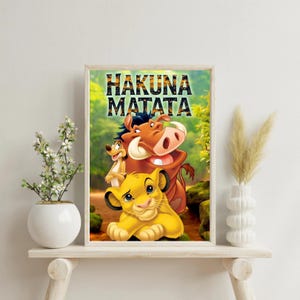 Może przedstawiać: Oprawiony wydruk z postaciami z Króla Lwa. Obrazek zawiera Simbę, Timona i Pumbę, ze słowami "Hakuna Matata" na górze. Tło to bujna, zielona scena leśna. Wydruk jest wyświetlany na białej półce.