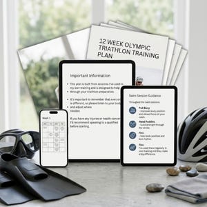 May include: A triathlon training plan displayed on a tablet, phone, and printed sheets. The plan includes swim session guidance, important information, and a 12-week Olympic triathlon training schedule. Accessories like goggles, fins, and a helmet are also visible.