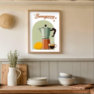 Puede incluir: Una impresión enmarcada con una ilustración de una cafetera, un limón y una taza de café, con la palabra italiana "Buongiorno". La obra de arte está en una cocina con estantes de madera y una encimera.