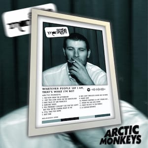 Peut inclure: Pochette d'album encadrée pour "Whatever People Say I Am, That's What I'm Not" des Arctic Monkeys. L'image présente une photo en noir et blanc d'un homme fumant, avec le titre de l'album et la liste des titres en dessous. Sorti en 2006.