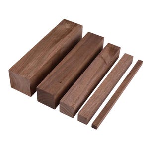 Peut inclure: Ensemble de blocs de bois de noyer rectangulaires de différentes tailles. Les blocs sont bruts, avec le grain du bois visible et une couleur brun moyen. Les tailles varient d'un grand bloc carré à une fine baguette. Mesures en centimètres.