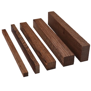 May include: Five rectangular wooden blocks of varying sizes, arranged diagonally. The wood has a rich, dark brown colour with visible grain patterns. The blocks are cut with clean, straight edges, suggesting they are ready for woodworking or crafts.