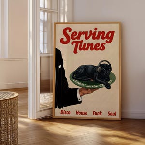 May include: A framed poster with a vintage aesthetic. The poster features the text "Serving Tunes" in red, above an illustration of a black panther wearing headphones, resting on a green plate. The words "Disco House Funk Soul" are at the bottom.