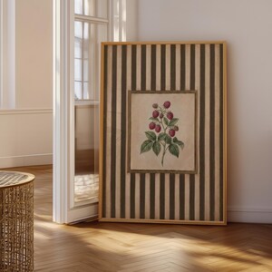 以下が含まれることがあります： 縦縞のダークブラウンとベージュの背景に、赤い実と緑の葉がついたラズベリーの枝の植物画が中央に描かれた、明るい木製フレーム入りの長方形の壁掛けアート作品です。
