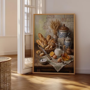 Op de afbeelding: Een ingelijst stilleven met een rustieke houten tafel met een rieten mand vol brood, een glazen kan met melk, een fles olie, rauwe eieren, een gesneden sinaasappel, een kom met zout en keramische potten tegen een bakstenen muur.
