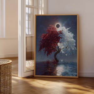 Op de afbeelding: Een ingelijste kunstdruk met een boom die in twee helften is verdeeld, de ene kant met dieprood gebladerte en de andere met witte bloesems, tegen een donkere lucht met een zonsverduistering boven een reflecterend wateroppervlak.
