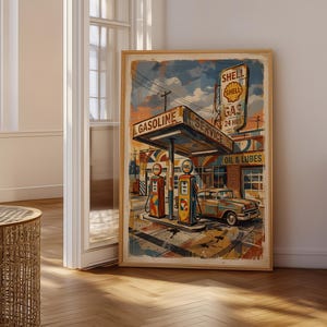 Könnte beinhalten: Ein gerahmter Vintage-Print einer Shell-Tankstelle. Das Kunstwerk zeigt ein klassisches Auto, Zapfsäulen und Schilder mit den Worten "Shell Gas 24 hrs" und "Oil & Lubes". Die Farbpalette umfasst Blau-, Orange- und Gelbtöne.
