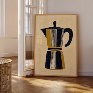 May include: A framed art print depicting a coffee maker illustration. The artwork uses navy blue, mustard yellow, and cream colours. The coffee maker design has vertical stripes and a dark handle. The print is in a wooden frame.