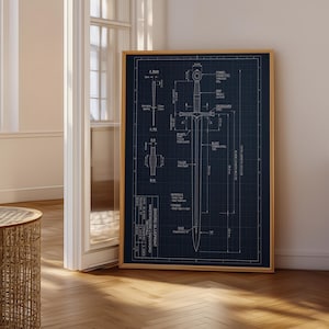 May include: A framed blueprint of a sword, rendered in white lines on a dark blue grid background. The design includes detailed measurements and technical annotations, presented in a wooden frame.
