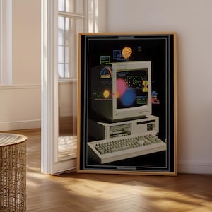May include: A framed print of a vintage computer, showcasing a monitor with vibrant data visualizations. The computer and keyboard are beige. The background is black, and the frame is light wood. The print is displayed in a room with a wooden floor.