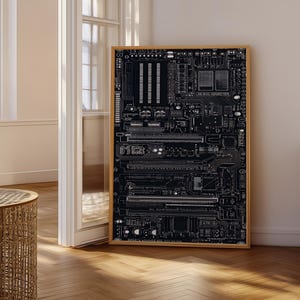 May include: A rectangular wall art piece featuring a detailed white line drawing of a computer motherboard on a solid black background, enclosed within a light-toned wooden frame. The intricate technical illustration displays various electronic components.