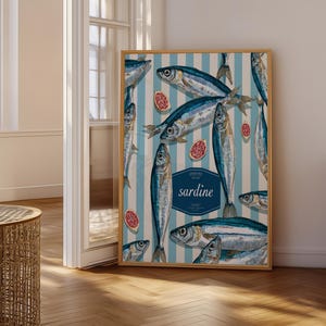 May include: A framed vertical poster featuring a repeating pattern of silver and blue sardines against a light blue and white striped background, interspersed with small red circular icons and a central dark blue label reading sardine.