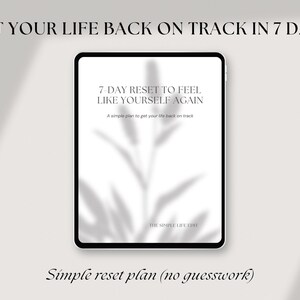 May include: A digital tablet displays text: "GET YOUR LIFE BACK ON TRACK IN 7 DAYS" and "7-DAY RESET TO FEEL LIKE YOURSELF AGAIN." The text is in black on a white background. The tablet is set against a neutral background with a shadow of leaves. The phrase "Simple reset plan (no guesswork)" is also visible.
