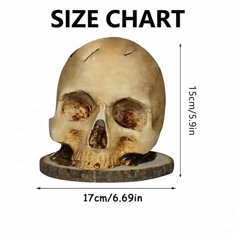 May include: A beige skull sculpture, 17cm/6.69in wide and 15cm/5.9in tall, sits on a wooden base. The skull has detailed facial features and is displayed against a white background. The text "SIZE CHART" is at the top.