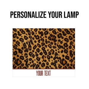 May include: A leopard print design with the text "PERSONALIZE YOUR LAMP" in black at the top. Below is a rectangular section with the text "YOUR TEXT" in a burgundy color.