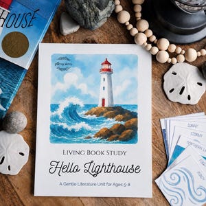 May include: A white educational booklet titled Living Book Study Hello Lighthouse A Gentle Literature Unit for Ages 5-8, featuring a watercolour illustration of a white lighthouse on a rocky shore with a large blue ocean wave and a cloudy sky.