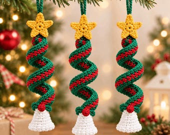 Op de afbeelding: Drie hangende kerstboomversieringen gemaakt van gehaakt garen. Elk ornament heeft een gele ster aan de bovenkant, een spiraalvormig lichaam in groen en rood, en een witte klokvormige basis. De ornamenten hangen aan lussen van groen garen.