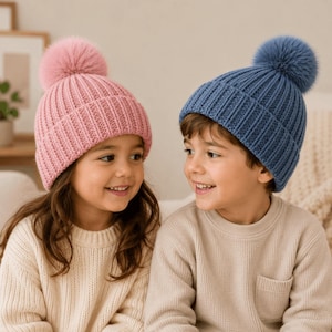 Pu&ograve; includere: Due berretti in maglia con pon pon, uno rosa chiaro e uno blu polvere. Entrambi i cappelli presentano una trama a coste verticali, un ampio risvolto piegato e un pon pon soffice abbinato sulla sommit&agrave;. Realizzati in filato morbido e spesso.