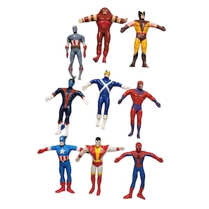 Könnte beinhalten: Eine Sammlung von Superhelden-Actionfiguren, darunter Captain America, Wolverine und Spider-Man. Die Figuren befinden sich in verschiedenen Posen und weisen leuchtende Farben wie Rot, Blau, Gelb und Braun auf. Die Figuren stehen mit ausgestreckten Armen.