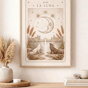 Può includere: Una stampa artistica incorniciata con un design celeste, con il testo "XVIII LA LUNA". L'opera raffigura una luna crescente con un volto, due lupi e un paesaggio. La tavolozza dei colori è neutra con toni beige e marrone.