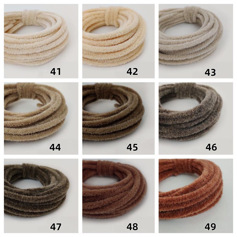 May include: Nine hair scrunchies in shades of cream, beige, brown, and rust. Each scrunchie is made from a soft, velvety fabric and is coiled into a circular shape. Numbers 41 to 49 are printed on the image.