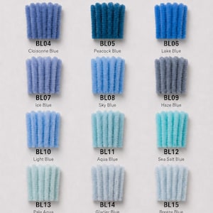 May include: A color chart featuring eighteen fuzzy pipe cleaner samples arranged in six rows and three columns. Each sample is labeled with a code and a color name, including Sapphire Blue, Deep Lake Blue, Ultramarine, Cloisonne Blue, Peacock Blue, Lake Blue, Ice Blue, Sky Blue, Haze Blue, Light Blue, Aqua Blue, Sea Salt Blue, Pale Aqua, Glacier Blue, Breeze Blue, Navy Blue, Slate Blue, and Dusty Blue.